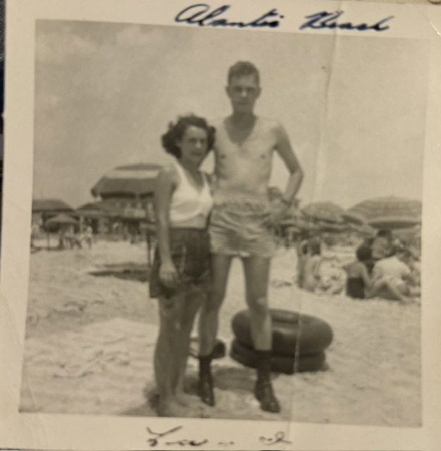 A woman and a young man at the beach with an inner tube